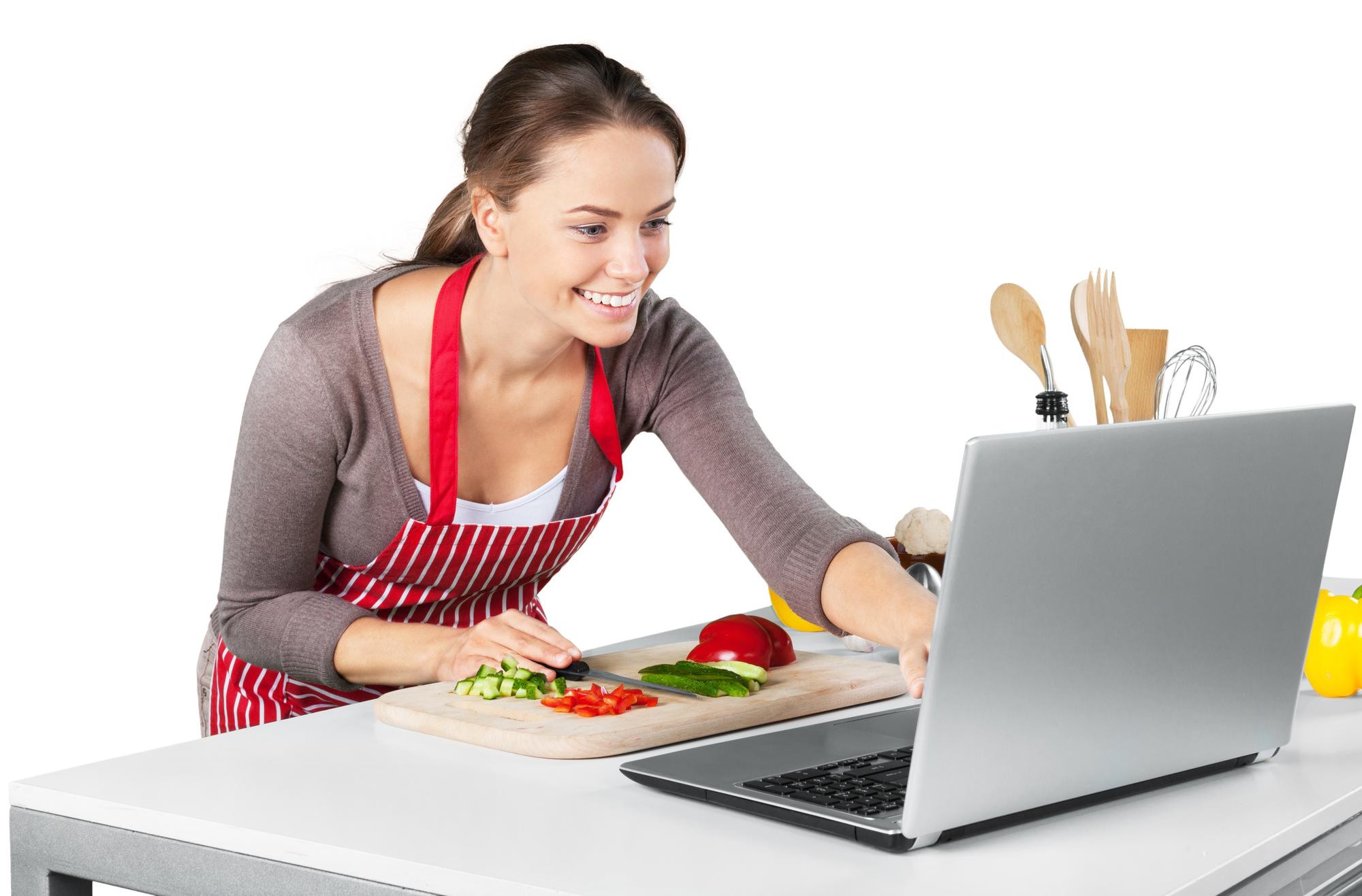 Chef guiding student in kitchen via laptop